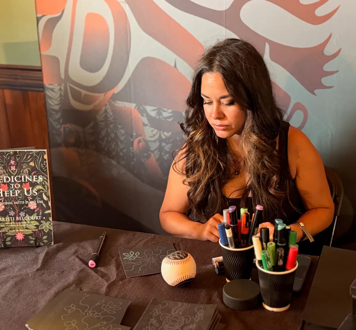 Michelle painting at a table at an event